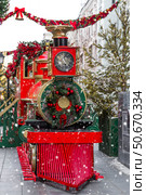 Christmas locomotive on the street of Moscow. New Year's postcard 2026. Beautiful Christmas background with a train. Concept of preparing decorations and attire for the New Year. Стоковое фото, фотограф Photojuli / Фотобанк Лори