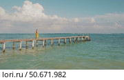 Woman walks along pier over clear blue Caribbean sea waters in Mexico. Стоковое видео, видеограф Igor Tichonow / Фотобанк Лори