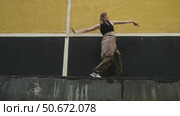 Attractive gen z young woman dancing contemporary dance against urban wall. Стоковое видео, видеограф Маргарита Кирьякова / Фотобанк Лори