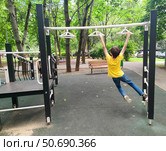 Ребёнок катается на турнике в парке. Стоковое фото, фотограф Ирина Терентьева / Фотобанк Лори