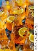 Close-up of refreshing Aperol Spritz cocktails with ice and orange slices, served in glasses at a party or reception. Стоковое фото, фотограф Башкирова Анна / Фотобанк Лори