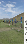 ELANTSY VILLAGE, IRKUTSK REGION, RUSSIA - July 05, 2025: Vertical video of female tourist placing offerings to spirits at  Serge pillars with traditional colorful ribbons near sacred mountain of Erd during Erdyn Games festival of nomadic peoples of Asia. Редакционное видео, видеограф Виктория Катьянова / Фотобанк Лори