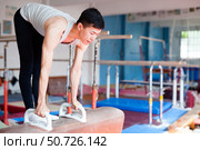 Male athlete doing complicated exciting trick on pommel horse in professional gym. Стоковое фото, фотограф Татьяна Яцевич / Фотобанк Лори