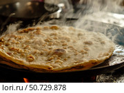 Fresh dough baking on hot griddle, releasing steam and creating golden brown bubbles. Стоковое AI-изображение, AI-художник Иван Рябоконь / Фотобанк Лори