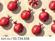 Ripe pomegranates forming appealing pattern on beige background. Стоковое AI-изображение, AI-художник Иван Рябоконь / Фотобанк Лори