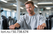 Handsome man working out on elliptical machine in gym. Стоковое AI-изображение, AI-художник Юрий Поздников / Фотобанк Лори