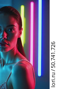 Woman under moody neon light looking deeply into camera, creating an artistic vibe for futuristic or retro themes footage. vertical video. Стоковое AI-видео, аниматор Анжелика Самсонова / Фотобанк Лори