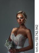 Portrait of Beautiful Blonde Bride Holding Flowers in Studio. Стоковое фото, фотограф Aleksandr Golubev / Фотобанк Лори