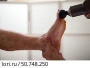 Explore the Soothing Effects of Gun Percussion Massage Therapy for Relaxation and Recovery. Стоковое фото, фотограф Aleksandr Golubev / Фотобанк Лори
