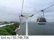 Lisbon, Portugal May 22. 2018 Telecabine Lisboa at Park of Nations Parque das Nacoes. Cable car in the modern district of Lisbon over the Tagus river. Vasco da Gama tower and bridge. Редакционное фото, фотограф Вера Федорова / Фотобанк Лори
