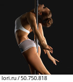 Young slim sexy brunette hangs on pylon in studio. Стоковое фото, фотограф Гурьянов Андрей / Фотобанк Лори