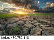 Dramatic sunset illuminating cracked soil during severe drought in cultivated field. Стоковое AI-изображение, AI-художник Иван Рябоконь / Фотобанк Лори