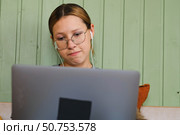 Teen girl school student wear headphones watching online webinar, talking through webcam looking at laptop. Teenager conducting video conference on computer at home, chatting online with friends. 4K. Стоковое фото, фотограф Марина Демидюк / Фотобанк Лори