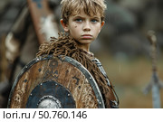 Young viking warrior boy holding shield in rainy weather. Стоковое AI-изображение, AI-художник Иван Рябоконь / Фотобанк Лори