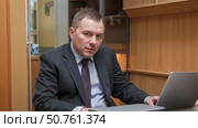 Corrupt government official in suit sits at his desk during an investigation for bribery, a shady politician involved in financial crime scheme for money. Стоковое AI-изображение, AI-художник Павел Муравьев / Фотобанк Лори