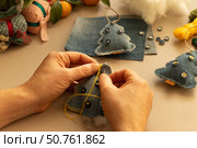 Female hands sews a felt Christmas tree on a light background. Christmas tree made from old denim. Стоковое фото, фотограф Оксана Шведкова / Фотобанк Лори