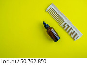 Cosmetic bottle and comb. Beauty salon, personal care products. Background with copy space. Стоковое фото, фотограф Юлия Николаева / Фотобанк Лори