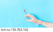 Banner with male hand in transparent vinyl disposable glove holding syringe above blue background with copy space. Safety first concept. Стоковое фото, фотограф Акимова Надежда / Фотобанк Лори