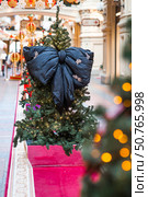 Beautiful Christmas background. Stylish black bow on the Christmas tree. Concept of preparing decorations and furnishings for the New Year. New Year's card 2026. Стоковое фото, фотограф Photojuli / Фотобанк Лори