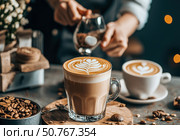 Aromatic Latte Art: Indulge in a handcrafted coffee drink with exquisite latte art, served in a clear glass. Coffee beans and cardamom pods add to the scene's charm. Стоковое AI-изображение, AI-художник Данила Большаков / Фотобанк Лори
