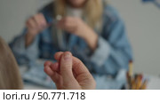 A tailor sews clothes by hand with a needle thread, and her colleague creates jewelry for skirt. Стоковое видео, видеограф Strunov David / Фотобанк Лори