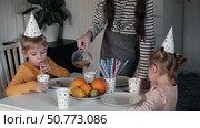 Children Drinking Juice on a Birthday Party at Home. Siblings, girls and a boy together celebrating a party, eating cake sitting at festive table. Little Kid Celebration. Surprise. Low key. Стоковое видео, видеограф Марина Демидюк / Фотобанк Лори