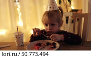 Children Eating Birthday Cake Slice on a Birthday Party at Home. Siblings, girls and a boy together celebrating a party, eating cake sitting at festive table. Little Kid Celebration. Surprise. Low key. Стоковое видео, видеограф Марина Демидюк / Фотобанк Лори