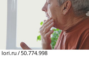 Senior Man shaving his face. Old male shaves beard and mustache with shaver. Elderly gray haired man looking at the mirror, applies shaving cream foam and using razor. Skin hygiene. Daily body care. Стоковое видео, видеограф Марина Демидюк / Фотобанк Лори