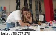 Two dressmakers make new jeans. They choose different things to put on the jeans to make them interesting. Стоковое видео, видеограф Strunov David / Фотобанк Лори