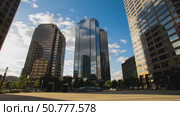 Modern skyscrapers reflecting clouds under blue sky in urban setting. Стоковое AI-видео, аниматор Андрей Бажанов / Фотобанк Лори