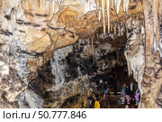 Tourists travel among the walls and vaults of the Bolshaya Azishskaya cave on the Lagonaki plateau in Adygea. Стоковое фото, фотограф Андрей С / Фотобанк Лори