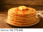 A Delicious Stack of Fluffy Pancakes Drenched in Maple Syrup with a Butter Pat Melting on Top, Perfect for Breakfast or Brunch Indulgence. Стоковое AI-изображение, AI-художник Башкирова Анна / Фотобанк Лори
