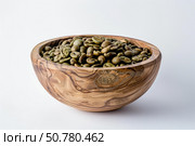 Green coffee beans filling a wooden bowl on white background. Стоковое AI-изображение, AI-художник Иван Рябоконь / Фотобанк Лори