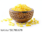 Golden raisins overflowing a carved wooden bowl on white background. Стоковое AI-изображение, AI-художник Иван Рябоконь / Фотобанк Лори