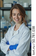 A Cheerful Woman in a Lab Coat Stands Confidently With Crossed Arms in a Bright Laboratory, Showcasing a Professional Atmosphere. Стоковое AI-видео, аниматор Sergey Grishin / Фотобанк Лори