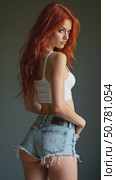Stylish Model in Denim Shorts and Red Hair Exudes Confidence While Posing for the Camera, Embodying Fashion and Photography. Стоковое AI-видео, аниматор Sergey Grishin / Фотобанк Лори