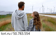 Father and daughter looking at solar panels. Solar farm and sunlight at sunset. Solar energy for green energy. Sustainable renewable energy. Photovoltaic power plant or solar park. Energy sustainability. Стоковое AI-изображение, AI-художник ALLA YURTAYEVA / Фотобанк Лори