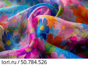 Colorful chiffon fabric with floral print flowing in soft folds. Стоковое AI-изображение, AI-художник Иван Рябоконь / Фотобанк Лори