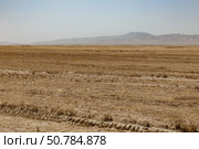 Vast arid landscape of Kunduz Province highlighting the barren terrain and distant mountains (2024 год). Стоковое фото, фотограф Михаил Пряхин / Фотобанк Лори