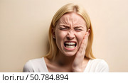 Blonde screams from toothache and holds her cheek. Стоковое AI-изображение, AI-художник Андрей Митин / Фотобанк Лори