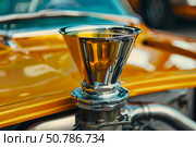 Velocity stack rising from a gleaming yellow hot rod. Стоковое AI-изображение, AI-художник Иван Рябоконь / Фотобанк Лори
