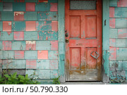 Weathered red door and checkered wall showing signs of age and neglect. Стоковое AI-изображение, AI-художник Иван Рябоконь / Фотобанк Лори