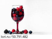 Long stemmed glass with red drink and raspberries and blackberries on white background. AI generative. Стоковое AI-изображение, AI-художник Роман Дзюбало / Фотобанк Лори