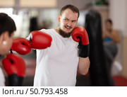 Man punches, tries to defeat guy opponent during training fight in ring. Стоковое фото, фотограф Яков Филимонов / Фотобанк Лори