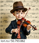 Little boy in formal suit and brown hat playing violin, realistic style, standing in front of a music sheet background, concept of child prodigy. Стоковое AI-изображение, AI-художник Александра Рублева / Фотобанк Лори