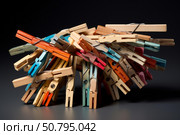 Colorful clothespins creating an intriguing structure on dark background. Стоковое AI-изображение, AI-художник Иван Рябоконь / Фотобанк Лори