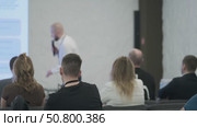 Participants Listening to a Speaker During a Business Presentation in a Modern Setting. Стоковое видео, видеограф Антон Гвоздиков / Фотобанк Лори