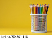 Close-Up of Vibrant Colorful Pencils in a pen holder isolated on yellow background. Banner, copy space. Colourful sharpened colored pencils for art projects, drawing, and creativity. Back to school. Стоковое AI-изображение, AI-художник Марина Демидюк / Фотобанк Лори