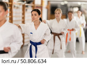 Young woman practicing punches standing in row with others. Стоковое фото, фотограф Яков Филимонов / Фотобанк Лори