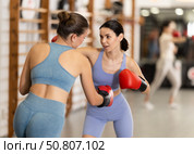 Women fight with hands, using all strength, courage during boxing lesson. Стоковое фото, фотограф Яков Филимонов / Фотобанк Лори